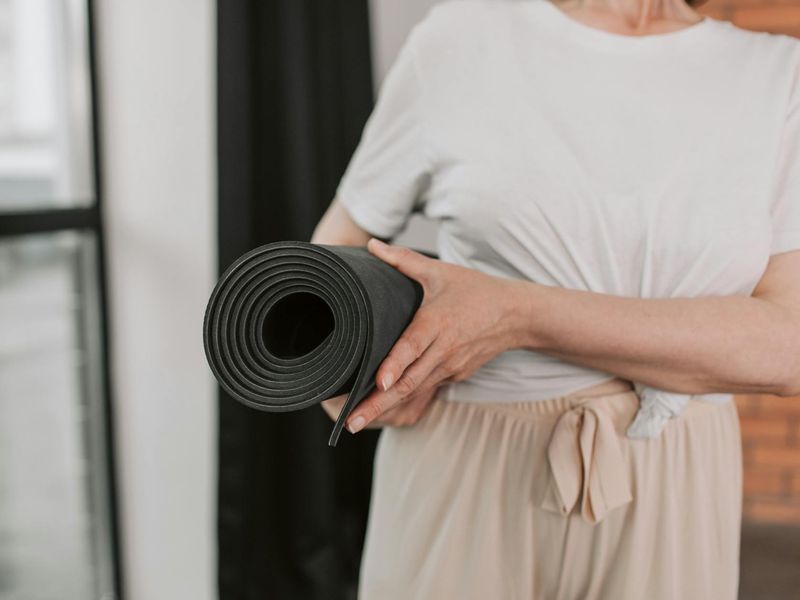 Detailed close-up of yoga mat and focused person's hands.